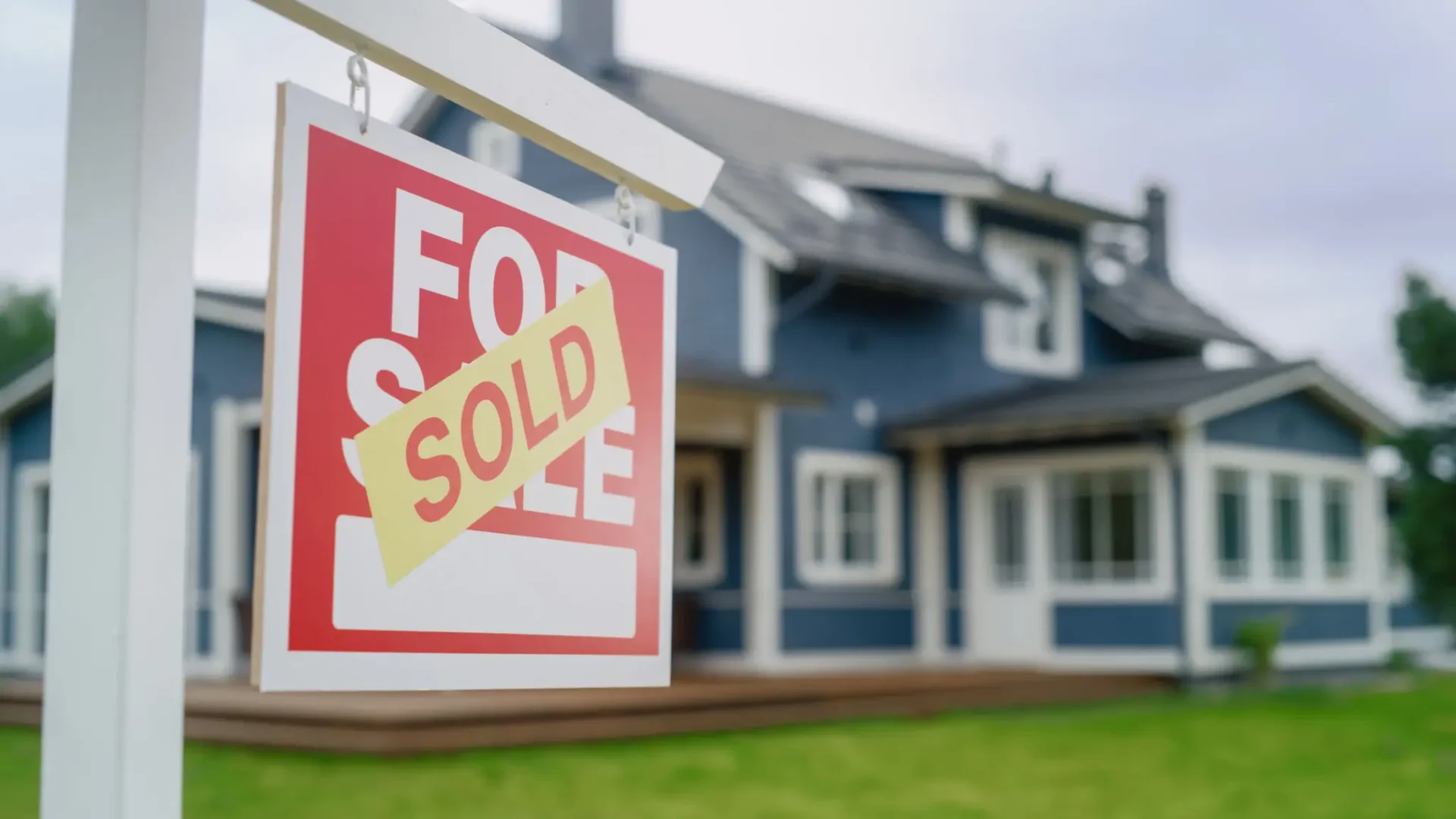 House with sold sign in front yard.