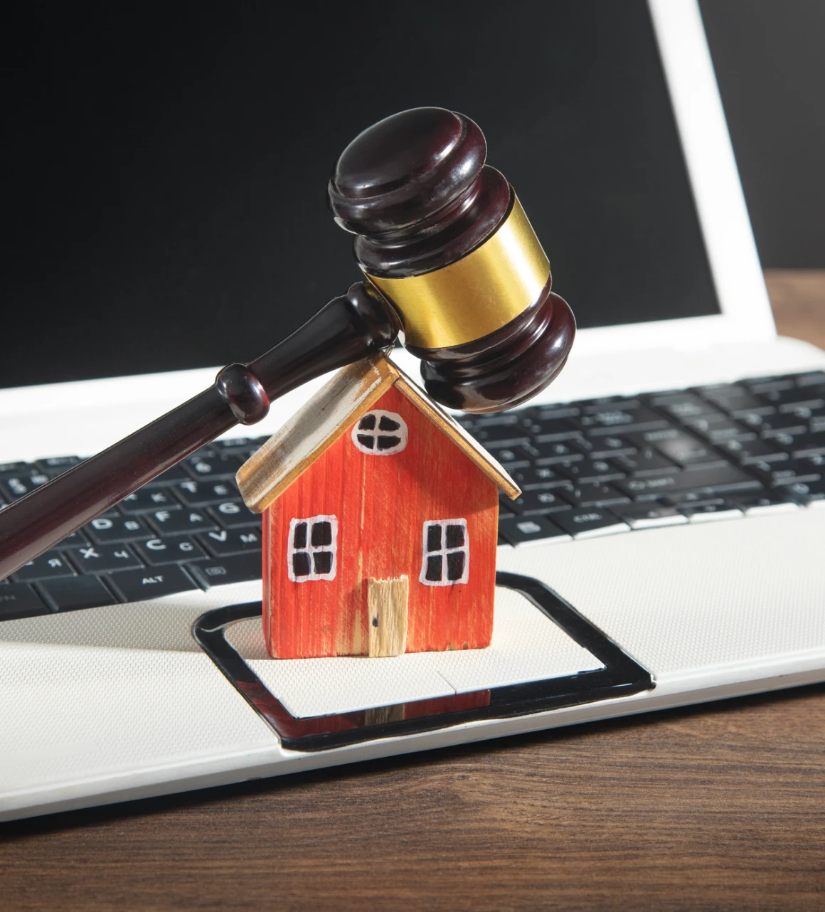 Gavel and house on a laptop.