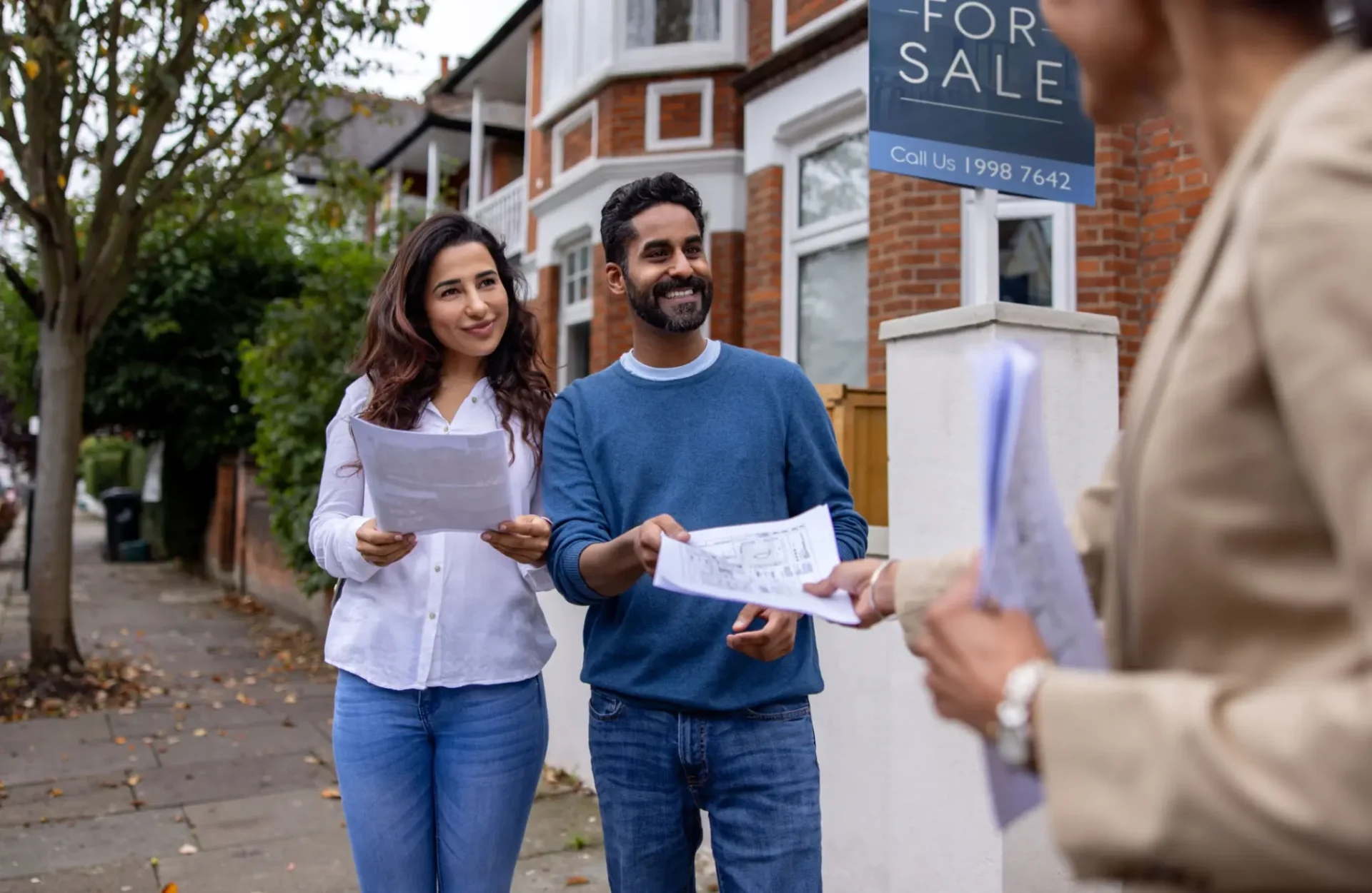 Couple viewing house with real estate agent.
