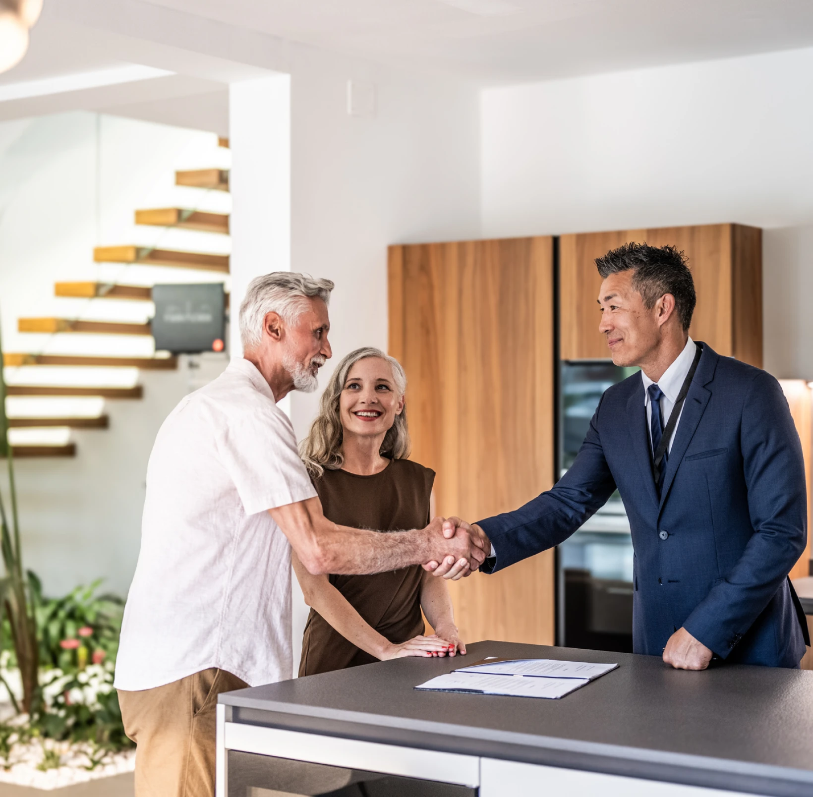 Couple shaking hands with real estate agent.