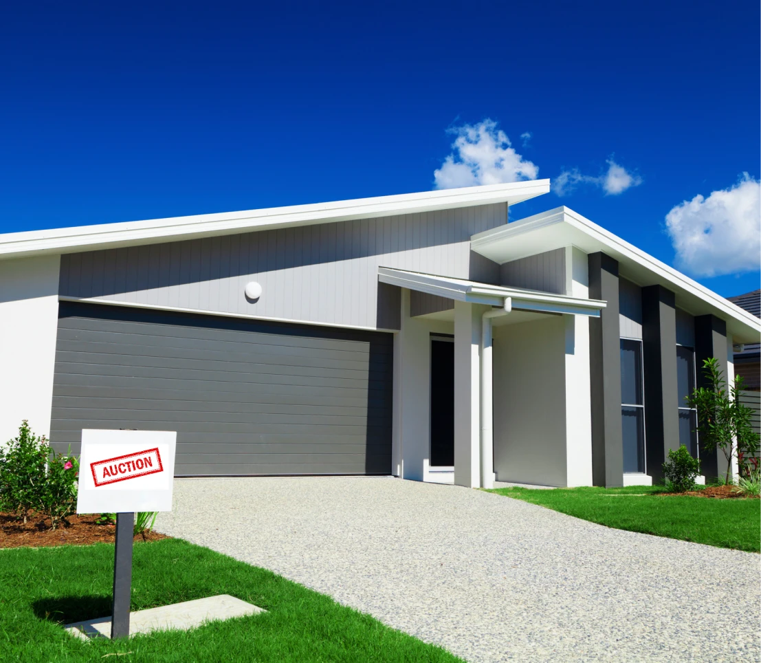 Modern house with auction sign outside.