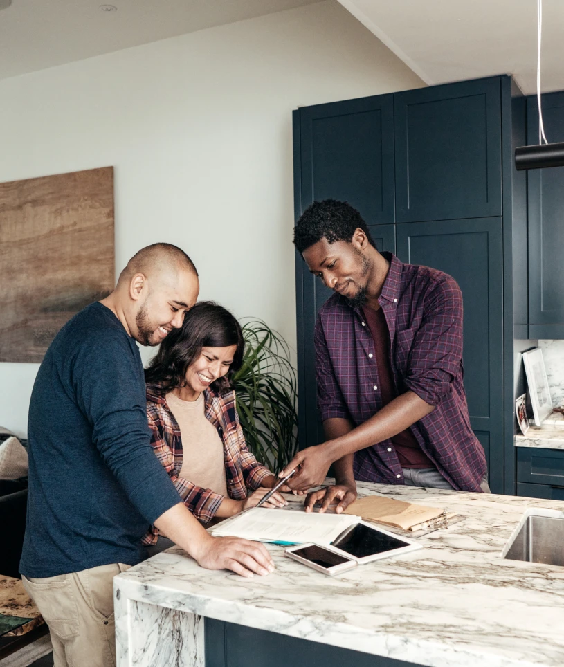 People reviewing documents in a modern kitchen.